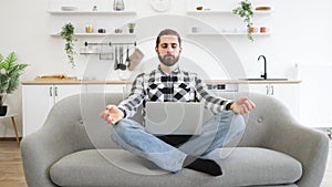 Peaceful caucasian businessman in casual attire sitting on couch with laptop.