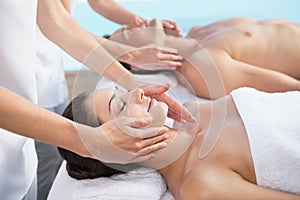 Peaceful couple enjoying couples massage poolside