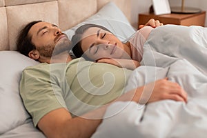 Peaceful couple sleeping together in bed