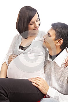 Peaceful Dreaming Caucasian Couple with Pregnant Woman Interacting While Sitting Embraced Against White Background