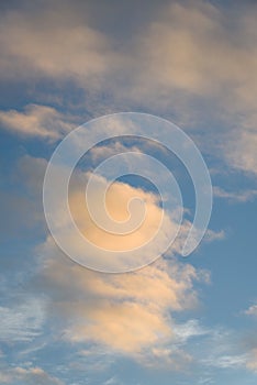 Peaceful evening light on white clouds and blue sky, as a nature background