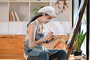 Peaceful female artist painting picture in art studio.