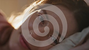 Peaceful female awaking morning sunlight closeup. Happy smiling girl open eyes