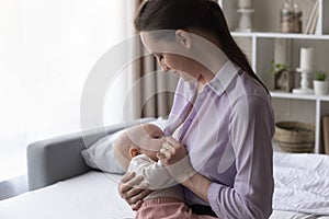 Peaceful happy mom breastfeeding baby at home