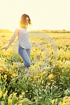 Peaceful happy woman strolling among a field of wild flowers and grasses