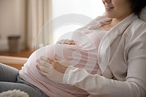 Peaceful happy young pregnant woman enjoying expectation