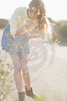 Peaceful hipster girl smelling flowers