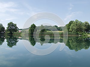 Peaceful lake with clouds and trees reflected in water