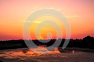 Peaceful lake at sunset with calm water and dramatic sky