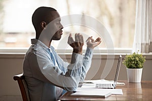 Peaceful millennial african american man deeply breathing, reducing stress.