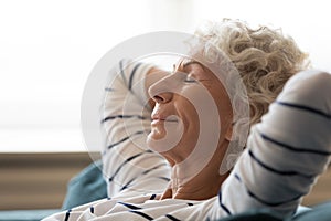 Peaceful mindful mature senior grandmother daydreaming at home.