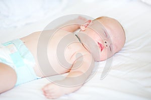 Peaceful newborn baby lying on a bed sleeping