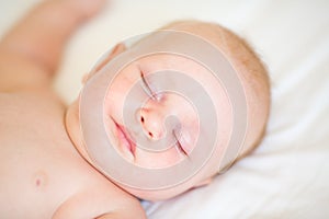 Peaceful newborn baby lying on a bed sleeping