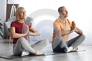 Peaceful pensioners sitting on fitness mat in lotus pose