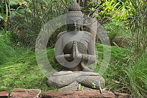 Peaceful praying Buddha sculpture in a garden