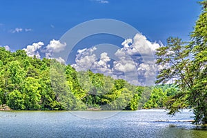 Peaceful River Background With Puffy Clouds and Blue Sky