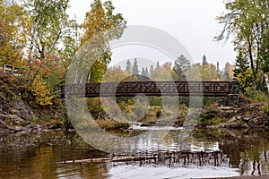 Peaceful scene of the bridge going over the Gooseberry River at Gooseberry Falls State Park Minnesota in autumn