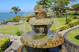 Peaceful scenery with fountain. Park near the Hindu Temple Tanah Lot, Bali, Indonesia. Small decorative fountain in tropical