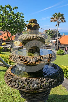 Peaceful scenery with fountain. Park near the Hindu Temple Tanah Lot, Bali, Indonesia. Small decorative fountain in tropical