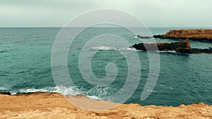 Peaceful seascape with rocks in wavy water, slow motion