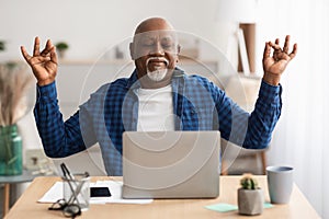 Peaceful Senior Black Man Meditating Sitting At Laptop At Workplace
