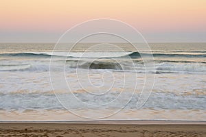 Peaceful sunset with pastel colours and empty beach blur