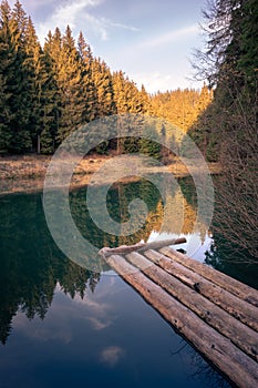 Peaceful sunset on a small lake in the middle of the woods. Trees reflection on the water surface. Autumn evening in the