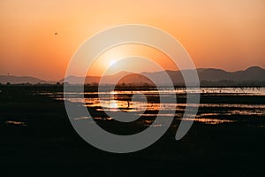 Peaceful sunset at small lake in Thailand with a mountain in the background