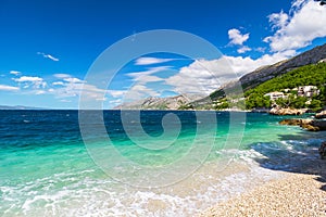 Peaceful and transparent summer sea, mountainous landscape in the background