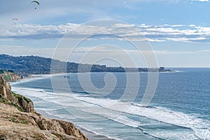 Peaceful view of calm beach in San Diego California bordered by steep mountain