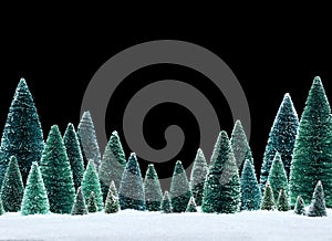 Peaceful winter scene with miniature snow covered trees on glittering snow