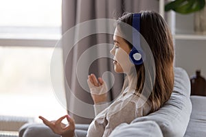 Peaceful woman in headphones listening to music and meditating