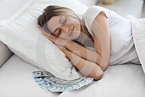 Peaceful woman sleeping with lots of cash