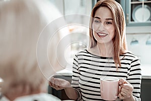 Peaceful woman smiling and talking to her mother in the kitchen