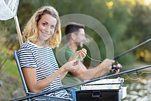 peaceful young couple fishing by pond