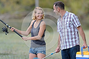 Peaceful young couple fishing by pond