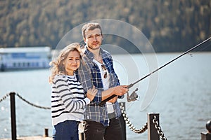 Peaceful young couple fishing with pond in autumn in lake