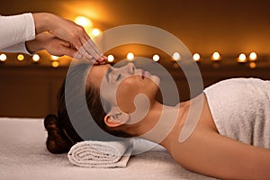 Peaceful young woman getting acupressure massage at modern luxury spa