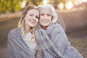 Peaceful young woman hugging aging mother at the picnic