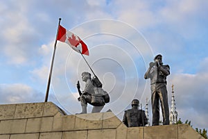 The Peacekeeping Monument, flag of Canada and cloudy sky.