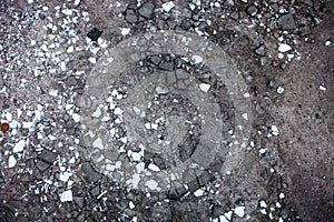 Peaces of damaged asphalt and white tiles on the ground