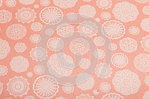 Peach background with snowflakes cut out of paper, scrapbooking paper