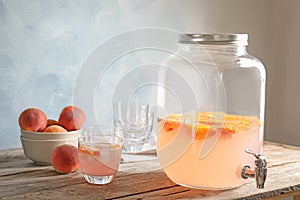 Peach cocktail in glass and jar with tap