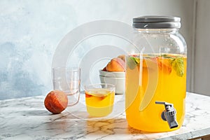 Peach cocktail in glass and jar with tap