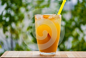 Peach cocktail or iced tea on a green background