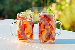 Peach cocktail with mint in the garden in hot summer, sunny day