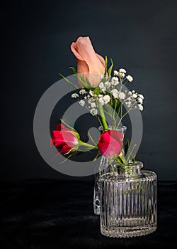 Peach colored rose bud in petite glass vase.