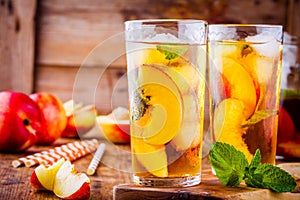 Peach ice tea in a glass with mint