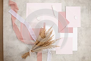 Peach pink pastel mock up composition of paper envelopes, seal wax, ribbons, hand craft jobbing. Weeding invitation. Top