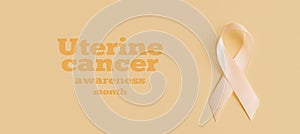 Peach Ribbon on beige background. Uterine Cancer Awareness month.